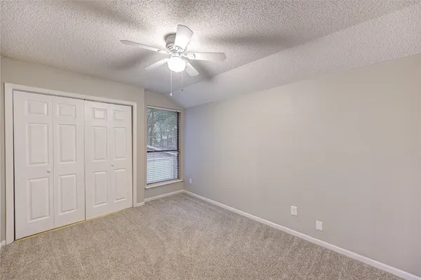 an empty room with chandelier fan