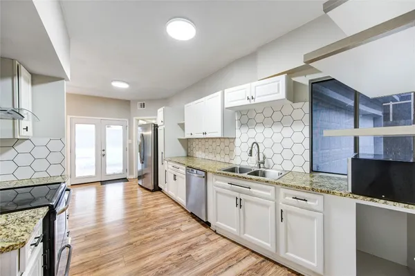 a kitchen with stainless steel appliances granite countertop a sink stove and refrigerator