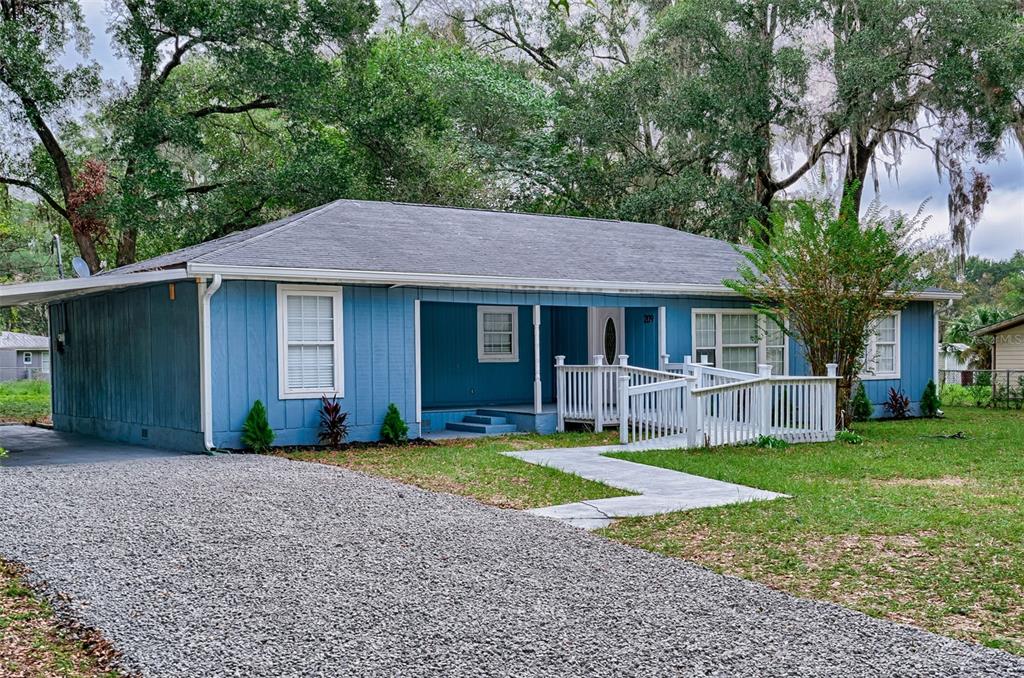 a front view of a house with a garden and yard