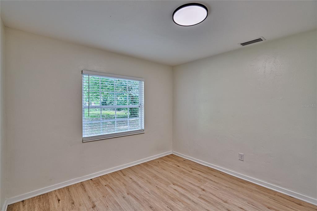 209 Southeast 47th Street Gainesville, FL 32641 - Photo 16 of 29 an empty room with wooden floor and windows
