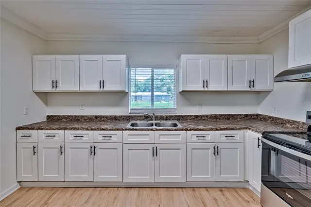 a kitchen with granite countertop cabinets stainless steel appliances and a sink