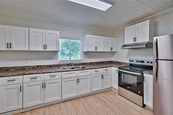 a kitchen with granite countertop white cabinets and white appliances