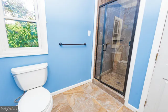 a bathroom with a toilet and a shower