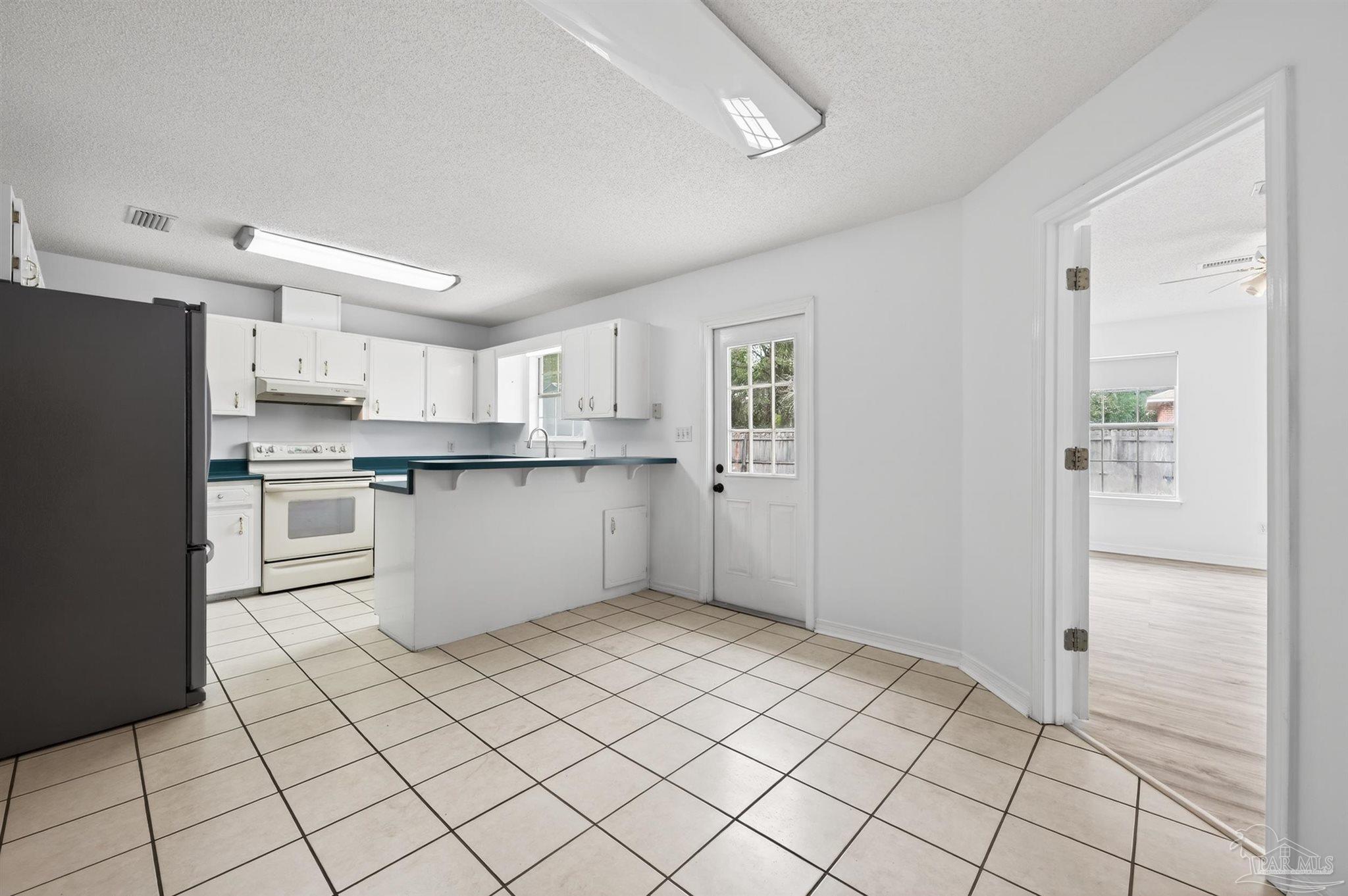 4885 Mayo Circle Pace, FL 32571 - Photo 14 of 44 a kitchen with white cabinets and white appliances
