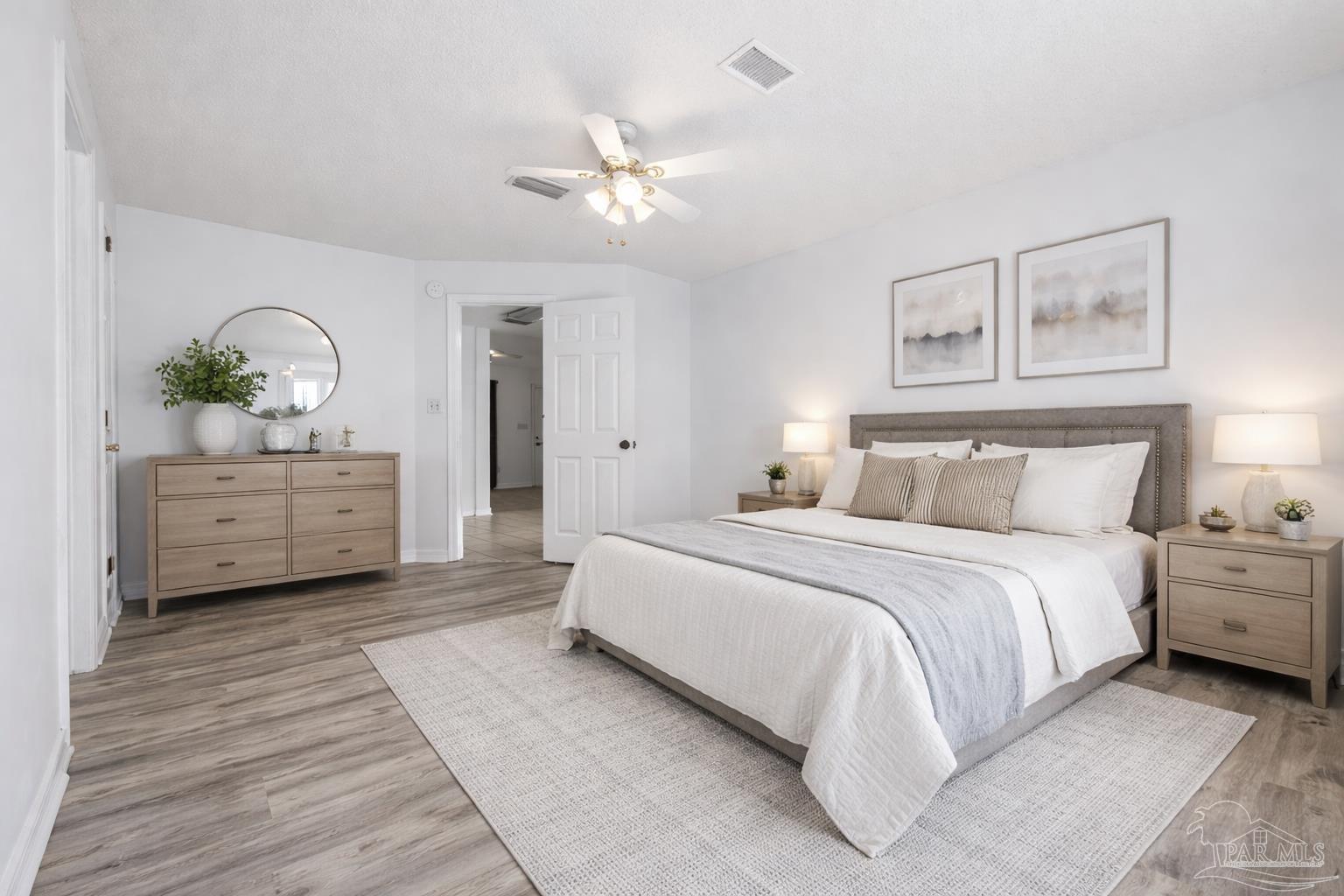 4885 Mayo Circle Pace, FL 32571 - Photo 16 of 44 a spacious bedroom with a bed and a potted plant