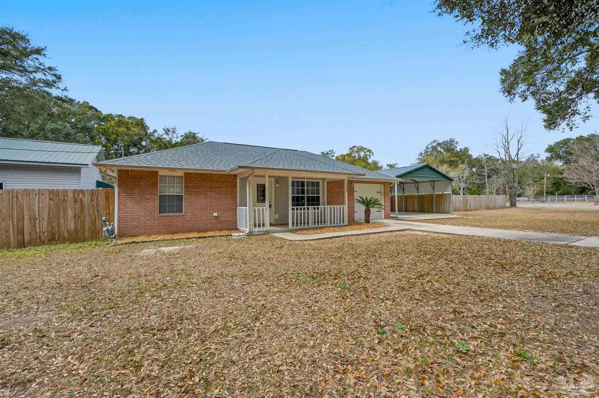 4885 Mayo Circle Pace, FL 32571 - Photo 2 of 44 a front view of house with yard and trees in the background