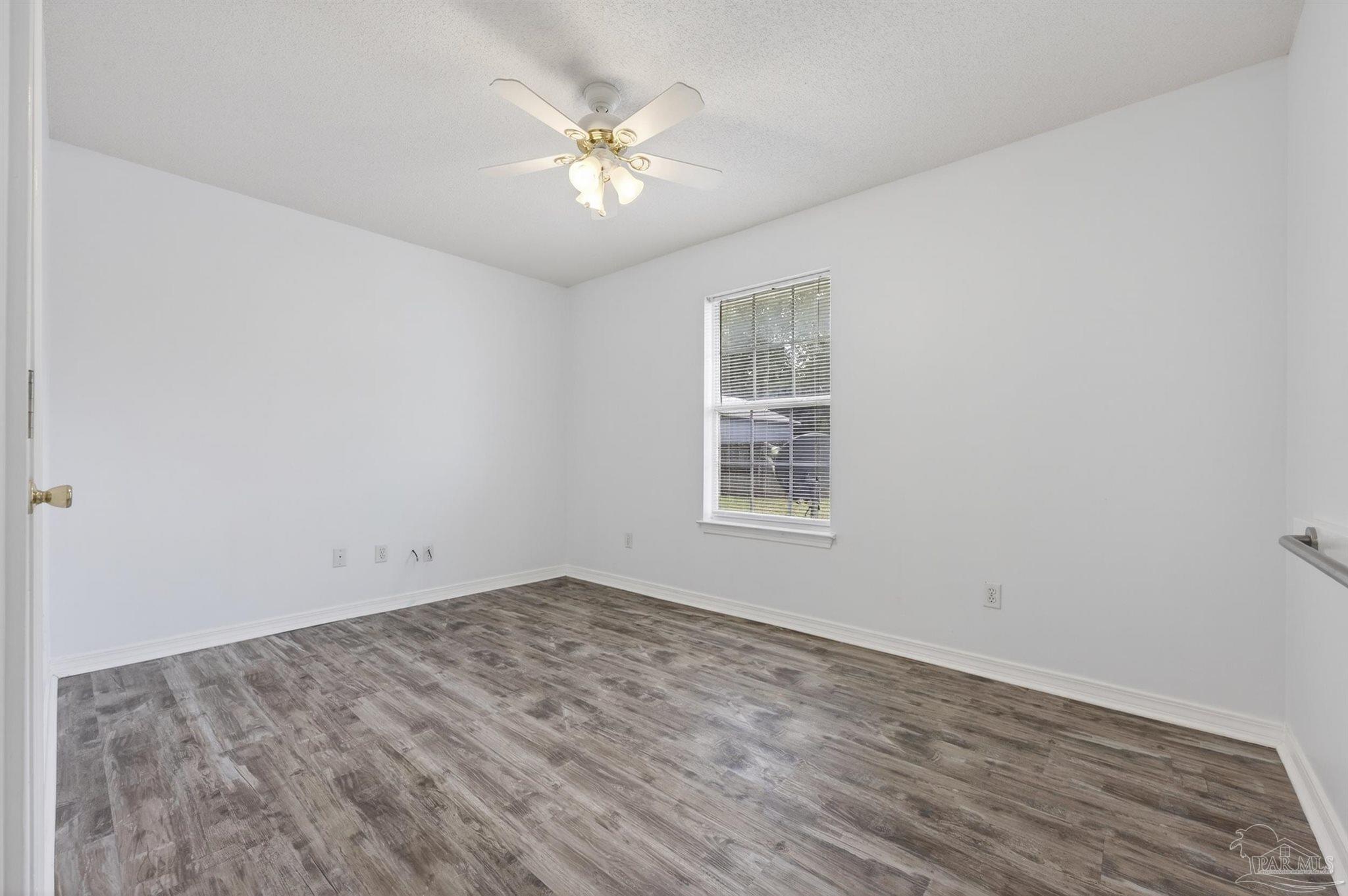 4885 Mayo Circle Pace, FL 32571 - Photo 29 of 44 an empty room with wooden floor and windows