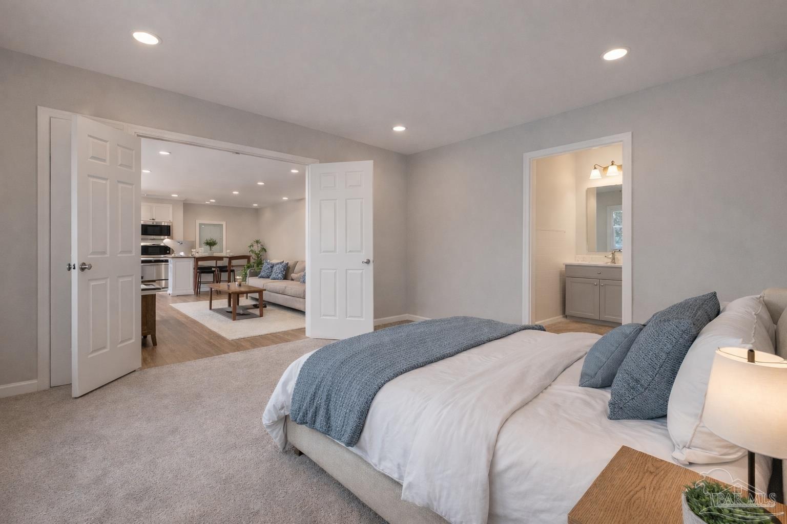 4885 Mayo Circle Pace, FL 32571 - Photo 40 of 44 a spacious bedroom with a bed a table and chairs