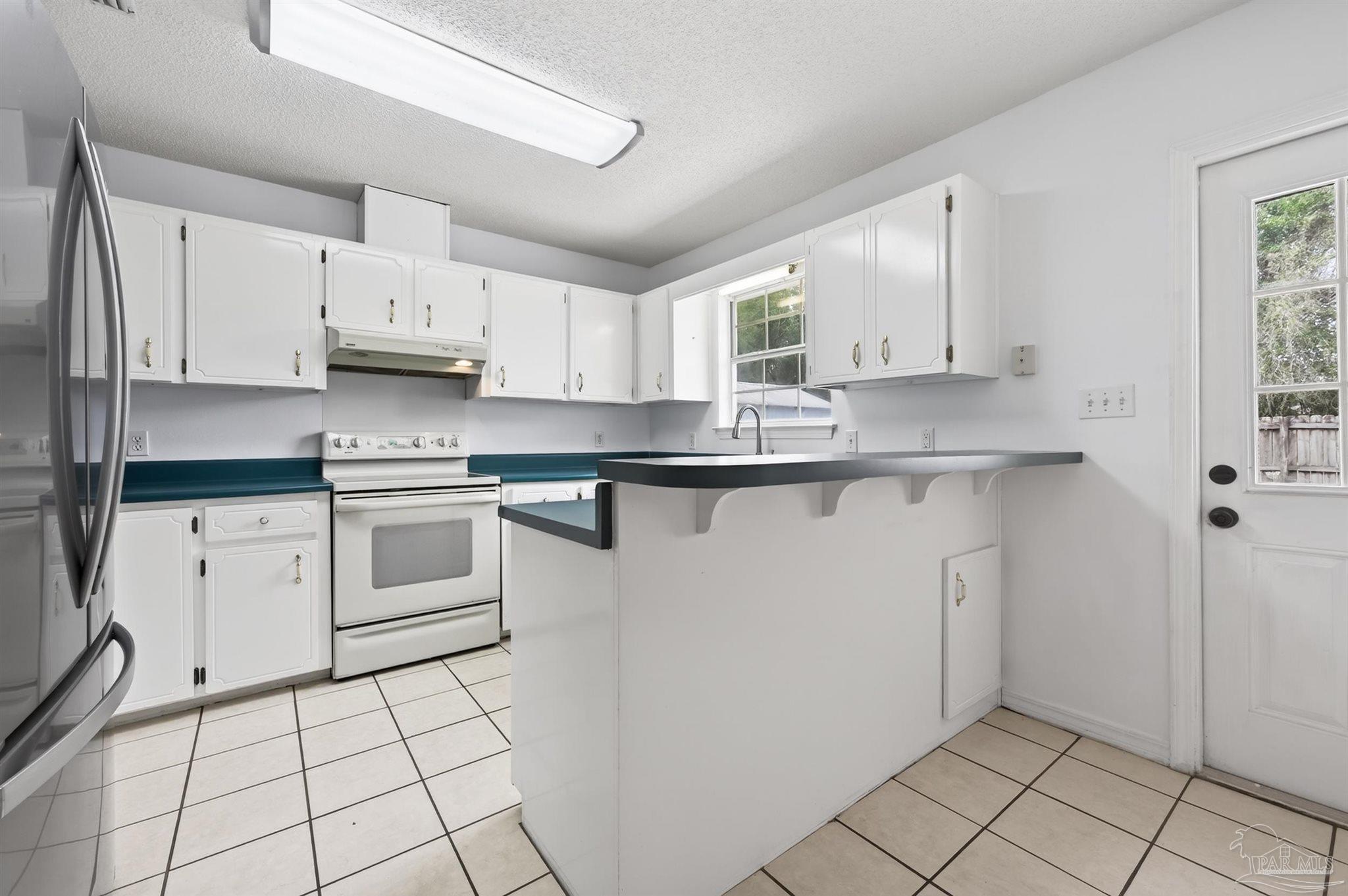 4885 Mayo Circle Pace, FL 32571 - Photo 8 of 44 a kitchen with white cabinets a sink and white appliances