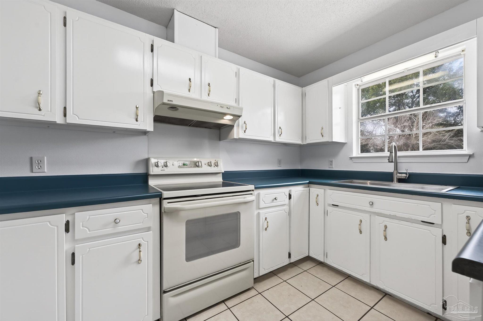 4885 Mayo Circle Pace, FL 32571 - Photo 9 of 44 a kitchen with granite countertop white cabinets and white stainless steel appliances