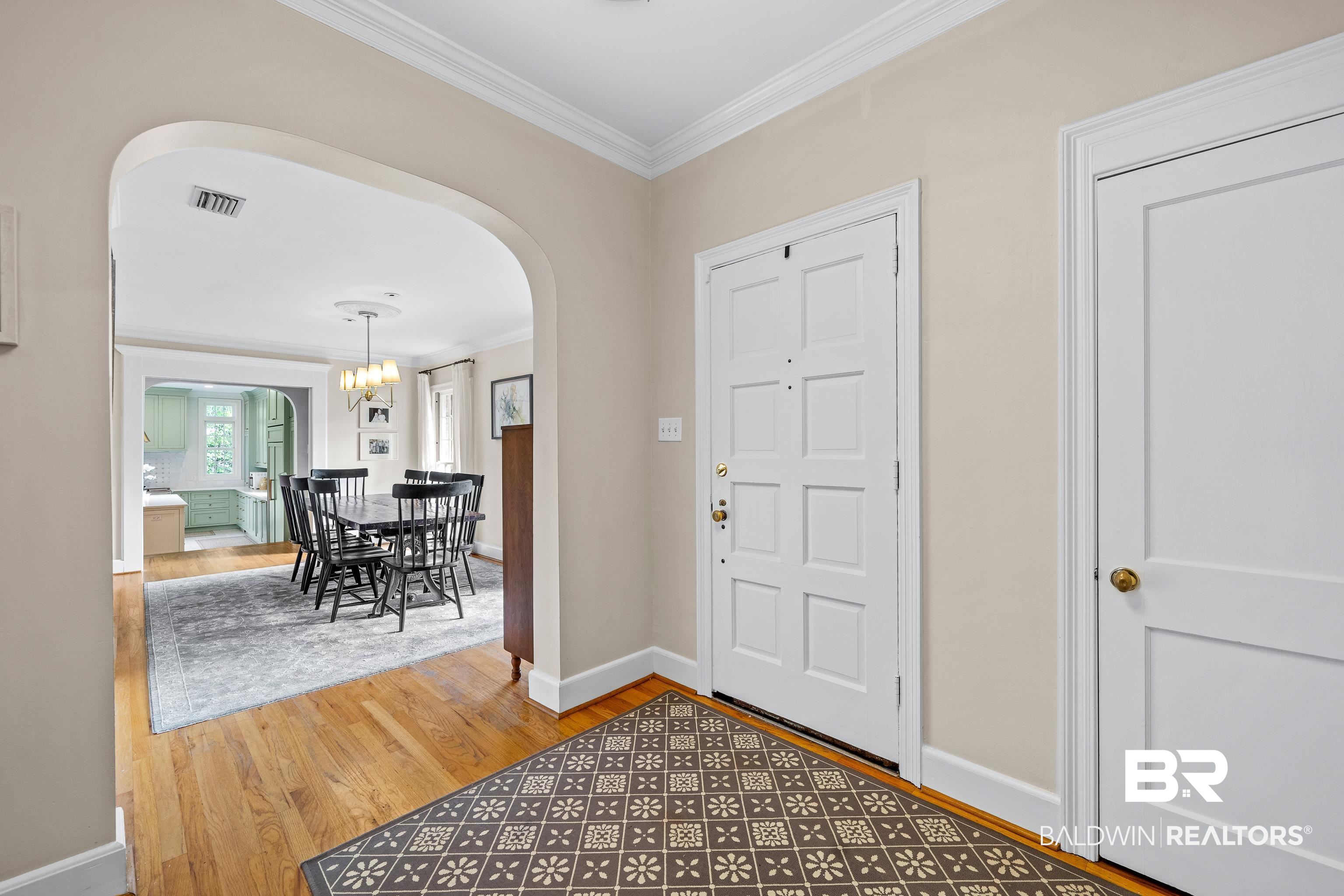 141 Myrtlewood Lane Mobile, AL 36608 - Photo 2 of 44 Entrance foyer featuring crown molding, an inviting chandelier, arched walkways, visible vents, and wood finished floors