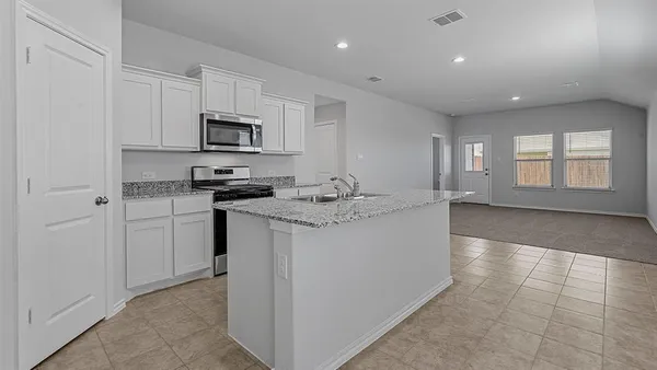 a front view of a house with a garden and plants