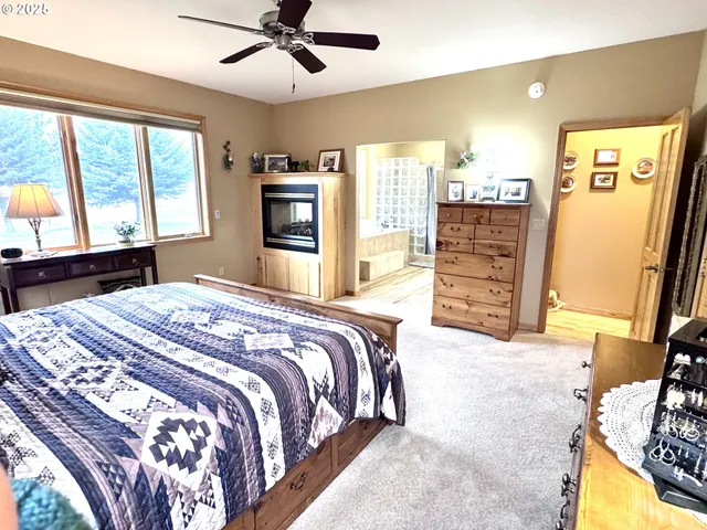a bedroom with a bed dresser and a large window