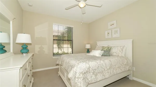 a living room with patio furniture and floor to ceiling window