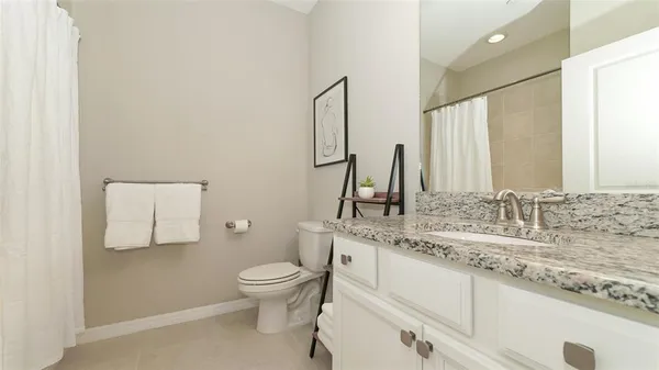 a view of a kitchen with stainless steel appliances granite countertop a sink dishwasher a flat tv screen and a dining table with wooden floor