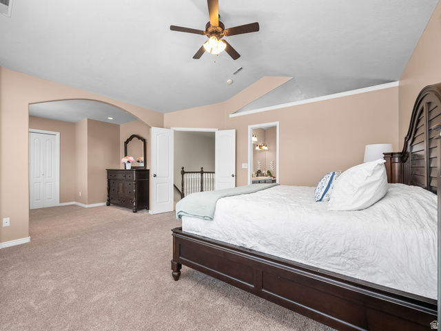 6849 North Black Powder Road Mountain Green, UT 84050 - Photo 13 of 43 Carpeted bedroom featuring an arched doorway, bi-fold closet doors, a ceiling fan with integrated lighting, and vaulted ceilings