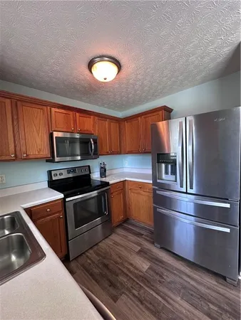 a kitchen with stainless steel appliances granite countertop a refrigerator and a sink