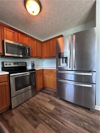 a kitchen with granite countertop stainless steel appliances and wooden cabinets