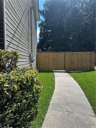 a view of backyard with potted plants and wooden fence