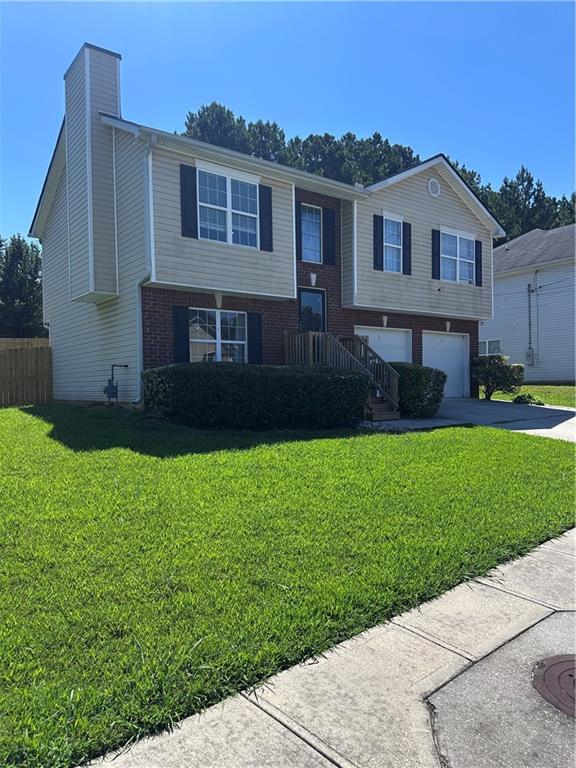 1591 Marceau Drive Conley, GA 30288 - Photo 6 of 47 a front view of a house with a garden and yard