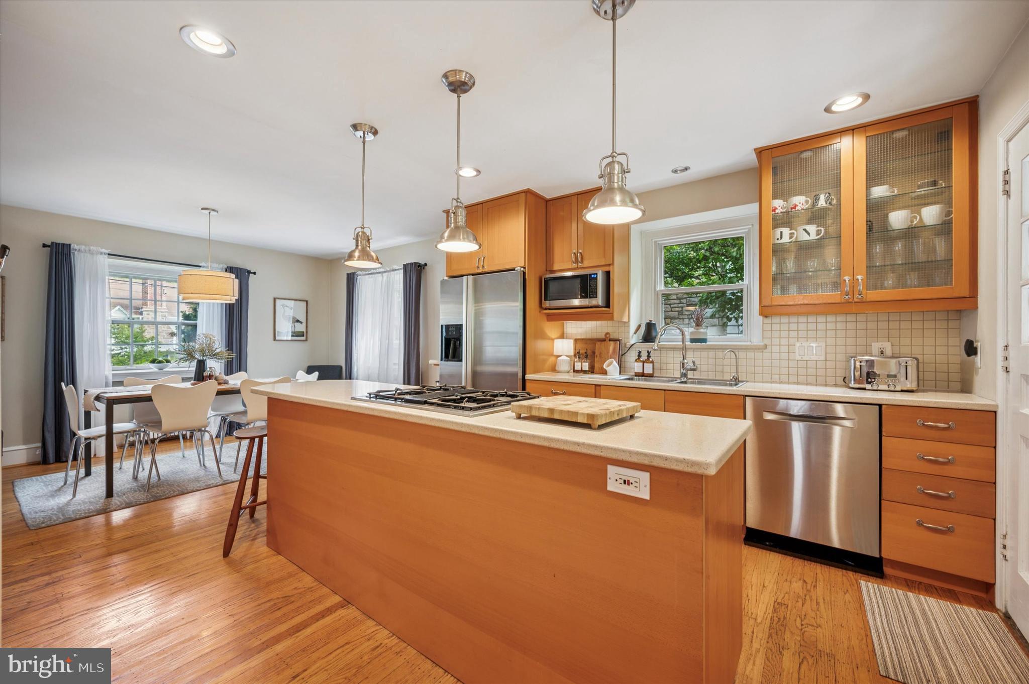 122 Waverly Road Wyncote, PA 19095 - Photo 10 of 30 a open kitchen with stainless steel appliances granite countertop a stove a sink dishwasher a dining table and chairs with wooden floor