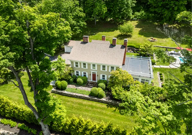 an aerial view of a house with swimming pool a yard and outdoor seating