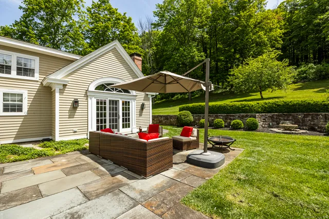 a view of a house with backyard sitting area and garden