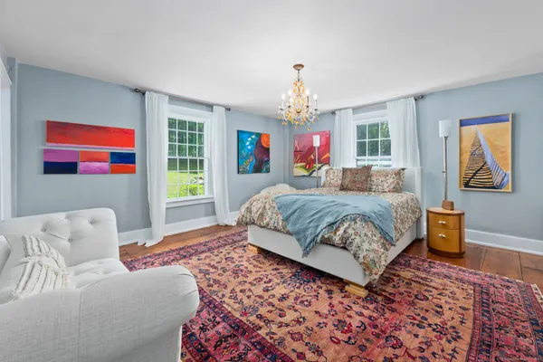 a bedroom with a bed wooden floor and window