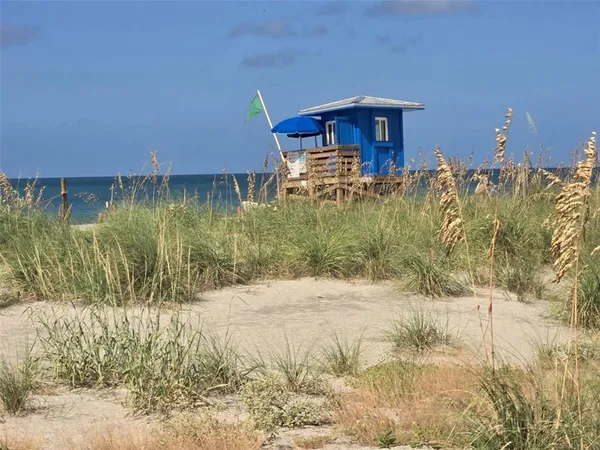 a front view of multi story residential apartment building with yard and flowers