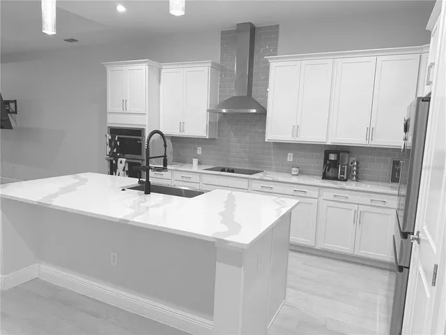 a kitchen with stainless steel appliances granite countertop a sink a stove and white cabinets