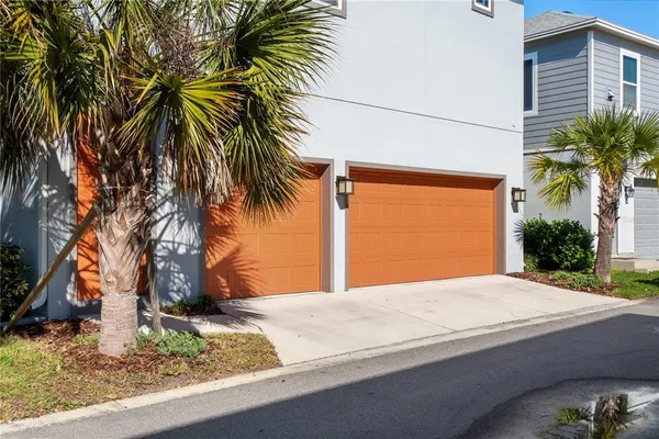 a palm tree sitting in front of a house with a yard