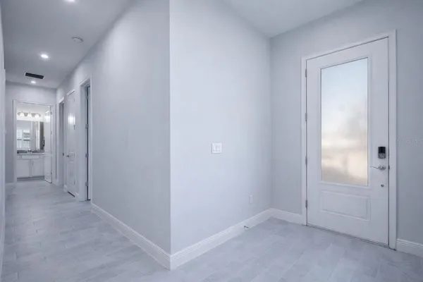 an empty room with mirror and a bathroom