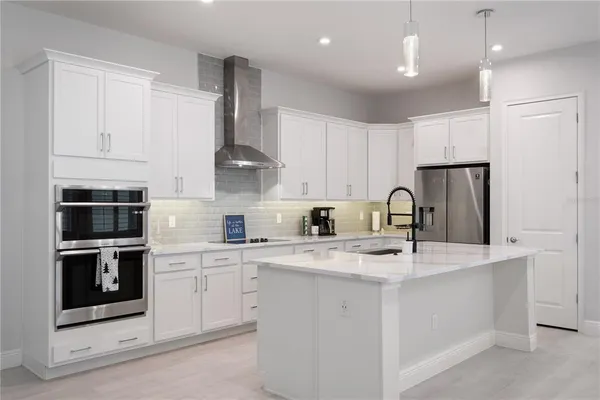 a kitchen with stainless steel appliances granite countertop a sink a stove a refrigerator and cabinets