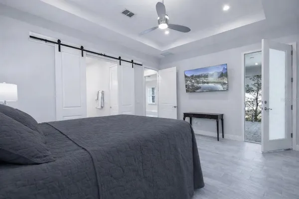 a spacious bedroom with a bed and a chandelier