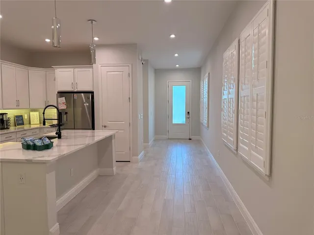 a kitchen with stainless steel appliances a sink a stove a refrigerator a center island and cabinets