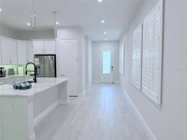 a kitchen with kitchen island granite countertop a sink and refrigerator
