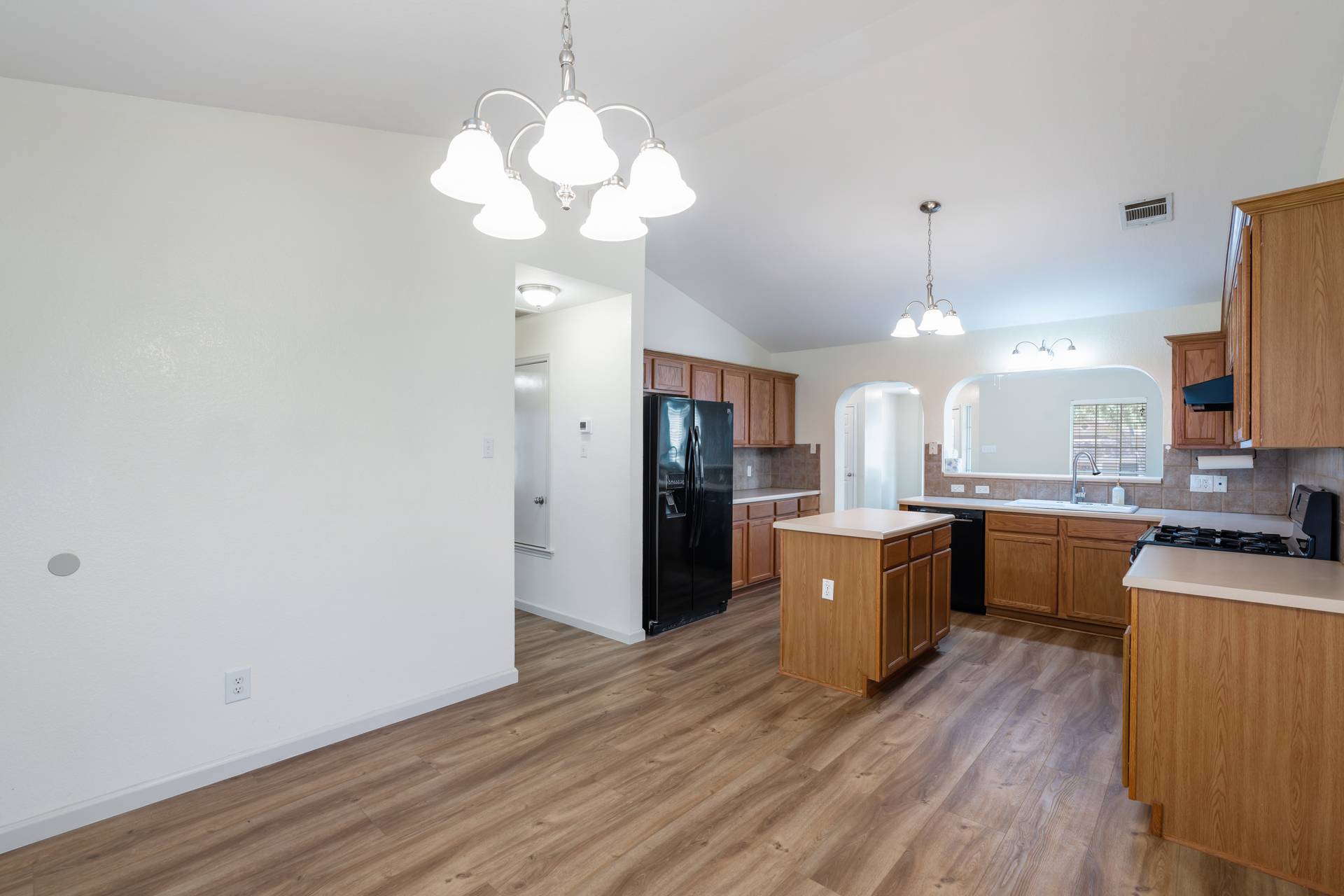 5911 Steiner Kyle, TX 78640 - Photo 14 of 36 a large kitchen with a wooden floor and cabinets