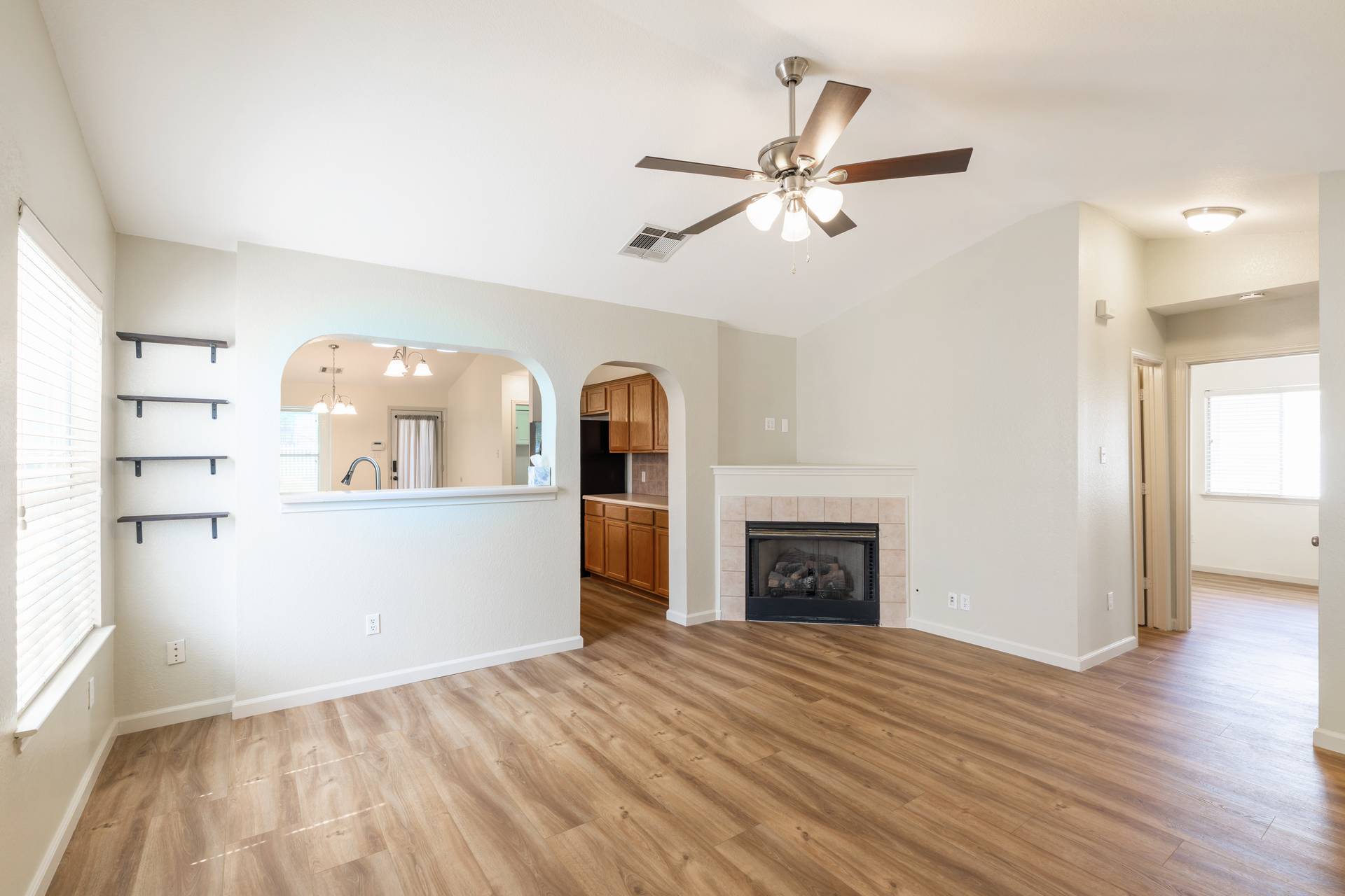 5911 Steiner Kyle, TX 78640 - Photo 20 of 36 wooden floor in an empty room with a fireplace and a window