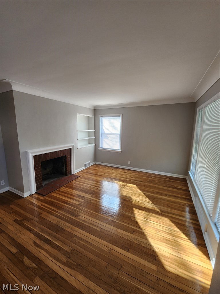 2199 North Taylor Road Cleveland Heights, OH 44112 - Photo 11 of 19 Unfurnished living room featuring a fireplace, dark wood-type flooring, and built in shelves