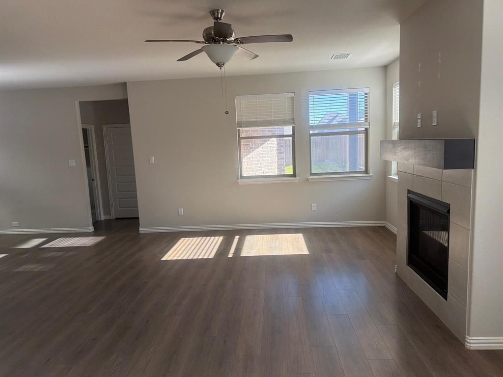 3936 Chesapeake Lane Forney, TX 75126 - Photo 2 of 40 an empty room with wooden floor fireplace and windows