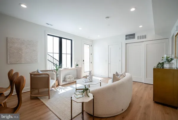 a living room with furniture a dining table and a potted plant
