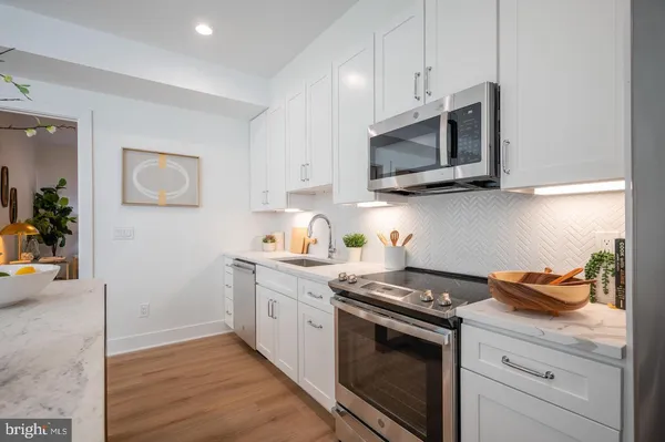 a kitchen with stainless steel appliances granite countertop a stove microwave and sink