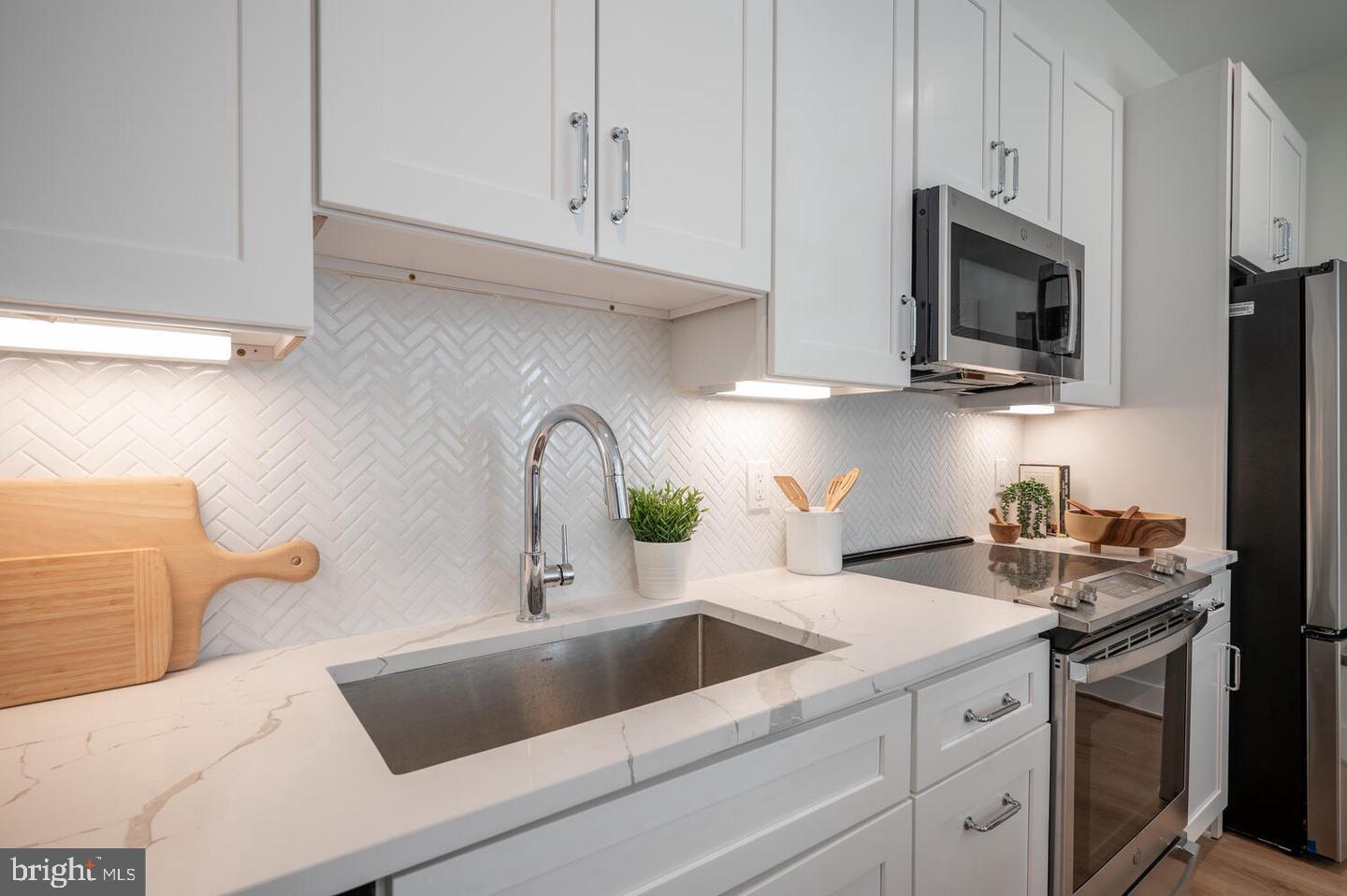1228 Brentwood Road Northeast, Unit 1 Washington, DC 20018 - Photo 8 of 21 a kitchen with stainless steel appliances granite countertop a sink a stove and a microwave