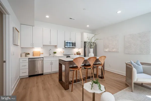 a view of kitchen with dining table chairs and wooden floor