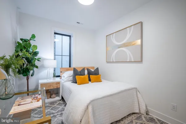 a bedroom with a bed and a potted plant