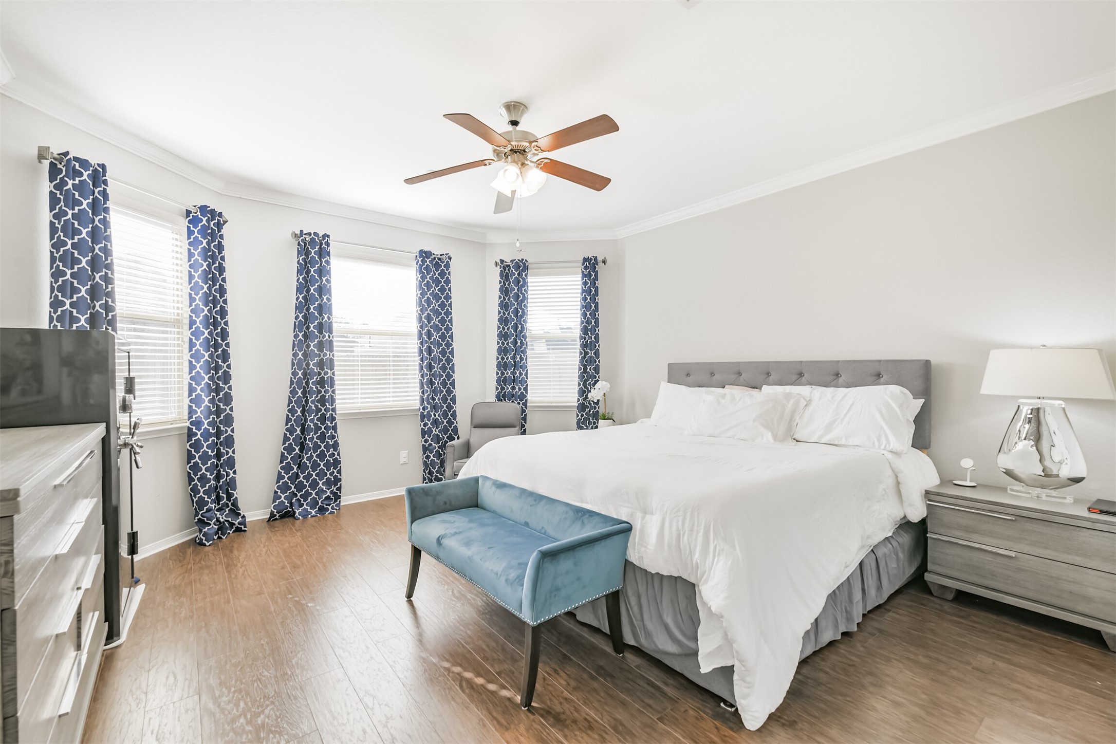 2602 Fort Settlement Trail Spring, TX 77373 - Photo 22 of 50 The primary bedroom features elegant bay windows, crown molding, custom window treatments, and a ceiling fan with an integrated light fixture for added comfort and style.