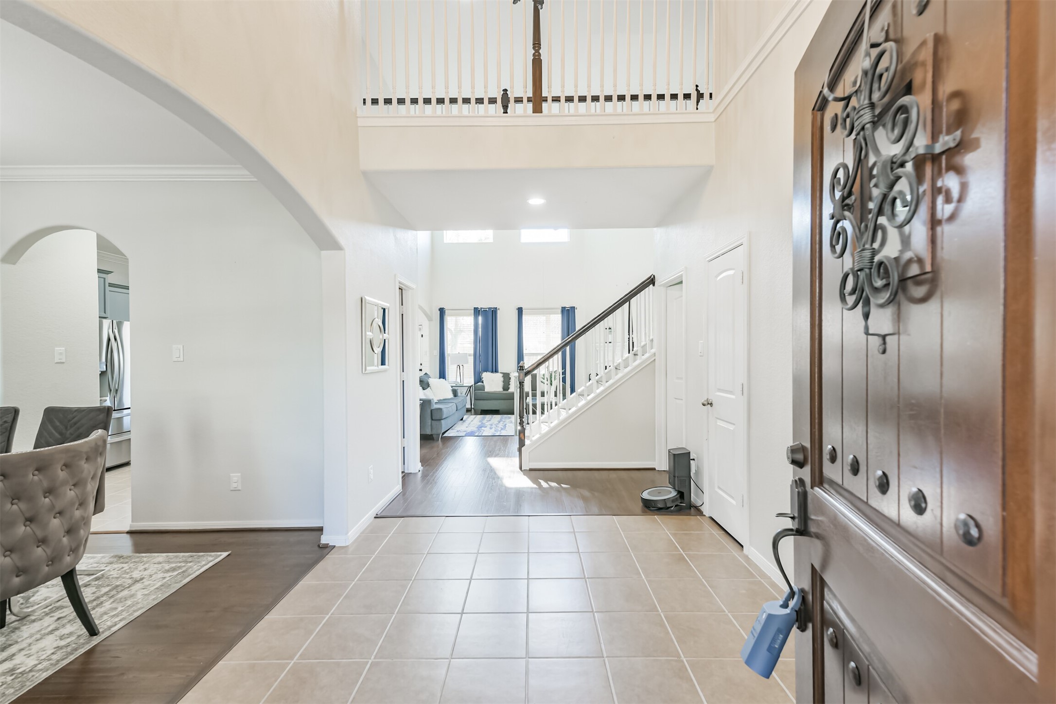 2602 Fort Settlement Trail Spring, TX 77373 - Photo 10 of 50 The foyer features a grand two-story entry with elegant ceramic tile flooring. A stylish catwalk overlooks the space, while an arched entryway leads to the formal dining room, adding a touch of sophistication.
