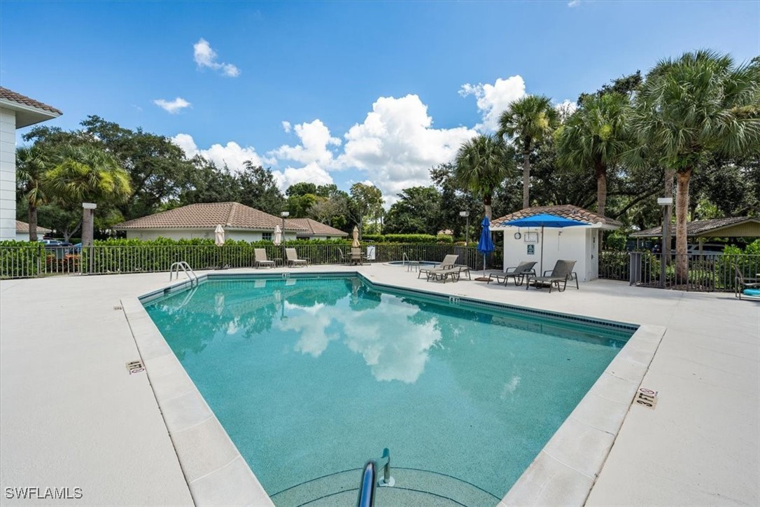 792 Eagle Creek Drive, Unit 101 Naples, FL 34113 - Photo 5 of 16 a view of a swimming pool with a deck and a garden