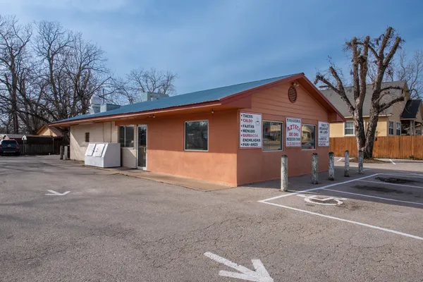 a front view of a house with a tree in front of it
