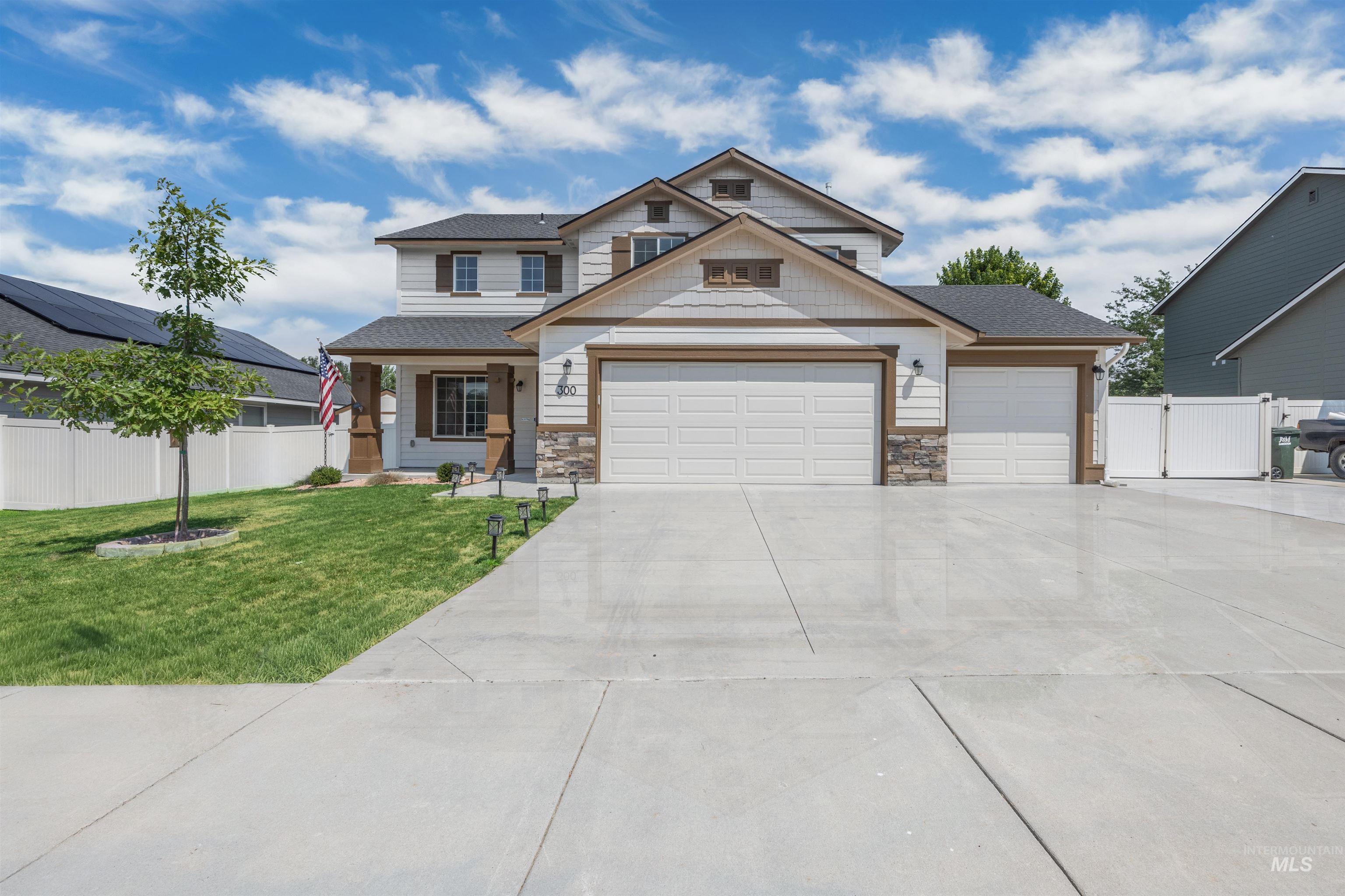 300 South Rocker Avenue Kuna, ID 83634 - Photo 2 of 49 Two-story residence featuring a covered front porch with wood-finish columns, a two-car garage, and an additional single-car garage